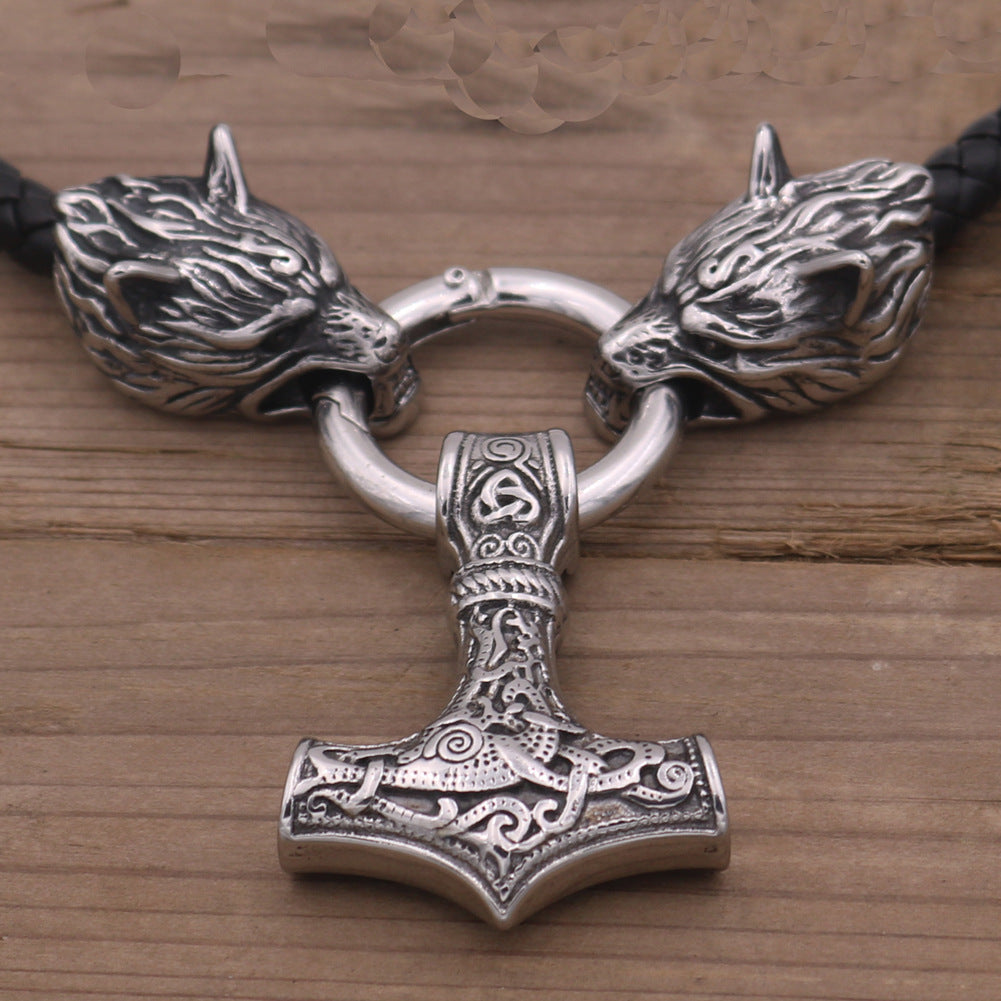 Collier Viking Tête de Loup présenté de face, affichant les détails des têtes de loup et le pendentif Mjöllnir, symbole de force et de protection nordique.

