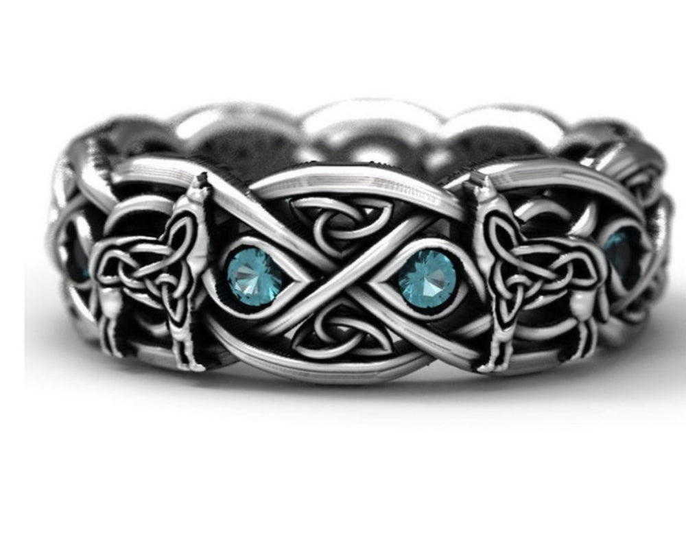 Anneau Loups Hurlants en métal renforcé, symbolisant la puissance et l'élégance nordique, avec détails gravés et pierres bleues éclatantes