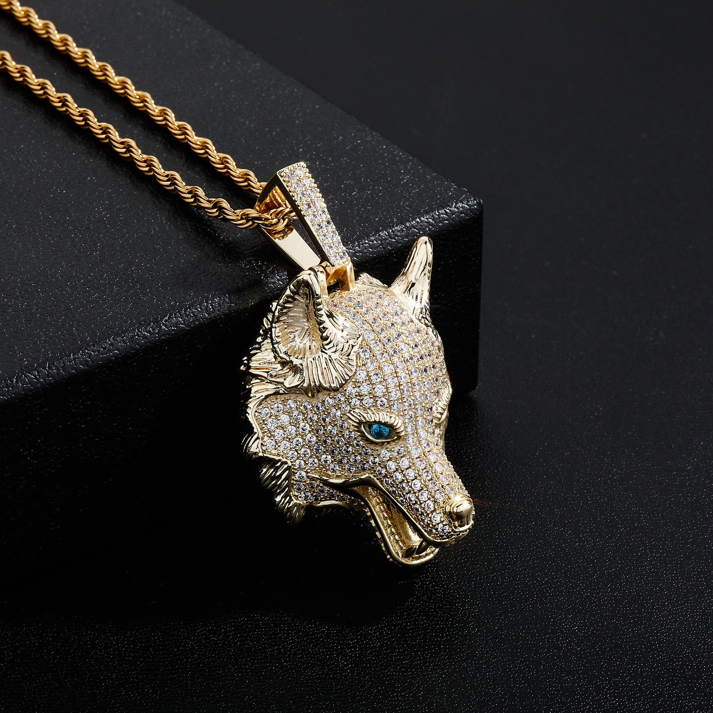 Gros plan du Collier Tête de Loup Luxueux en or, avec des yeux bleus perçants qui apportent une touche de prestige et de mystère.

