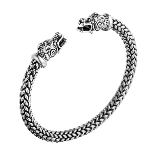 "Bracelet Torc Tête de Loup Gris en acier inoxydable, avec un design torsadé et des détails précis sur les têtes de loup. Bijou unisexe élégant et mythique."

